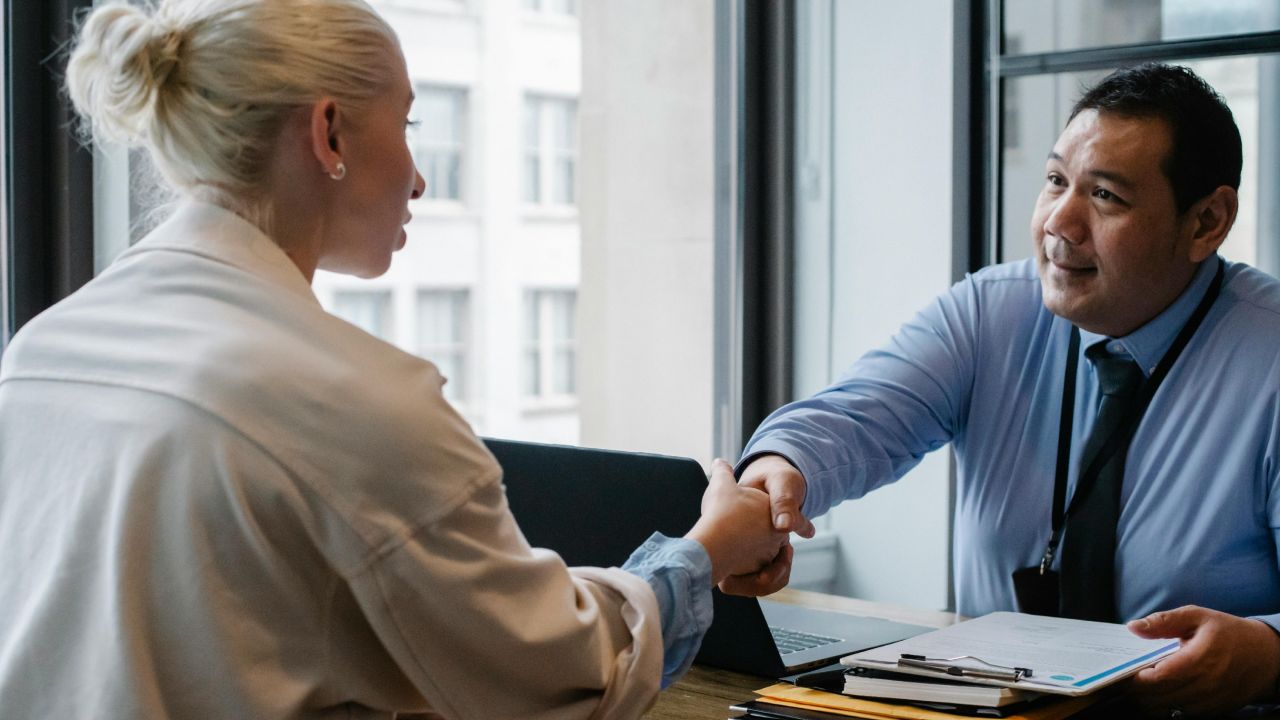 Consulente edile che stringe la mano a una donna
