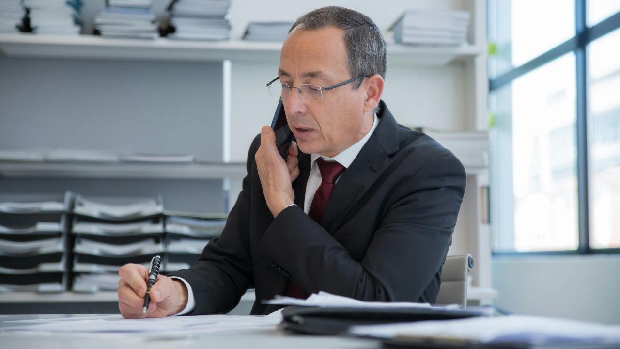 Persona che parla al telefono mentre scrive