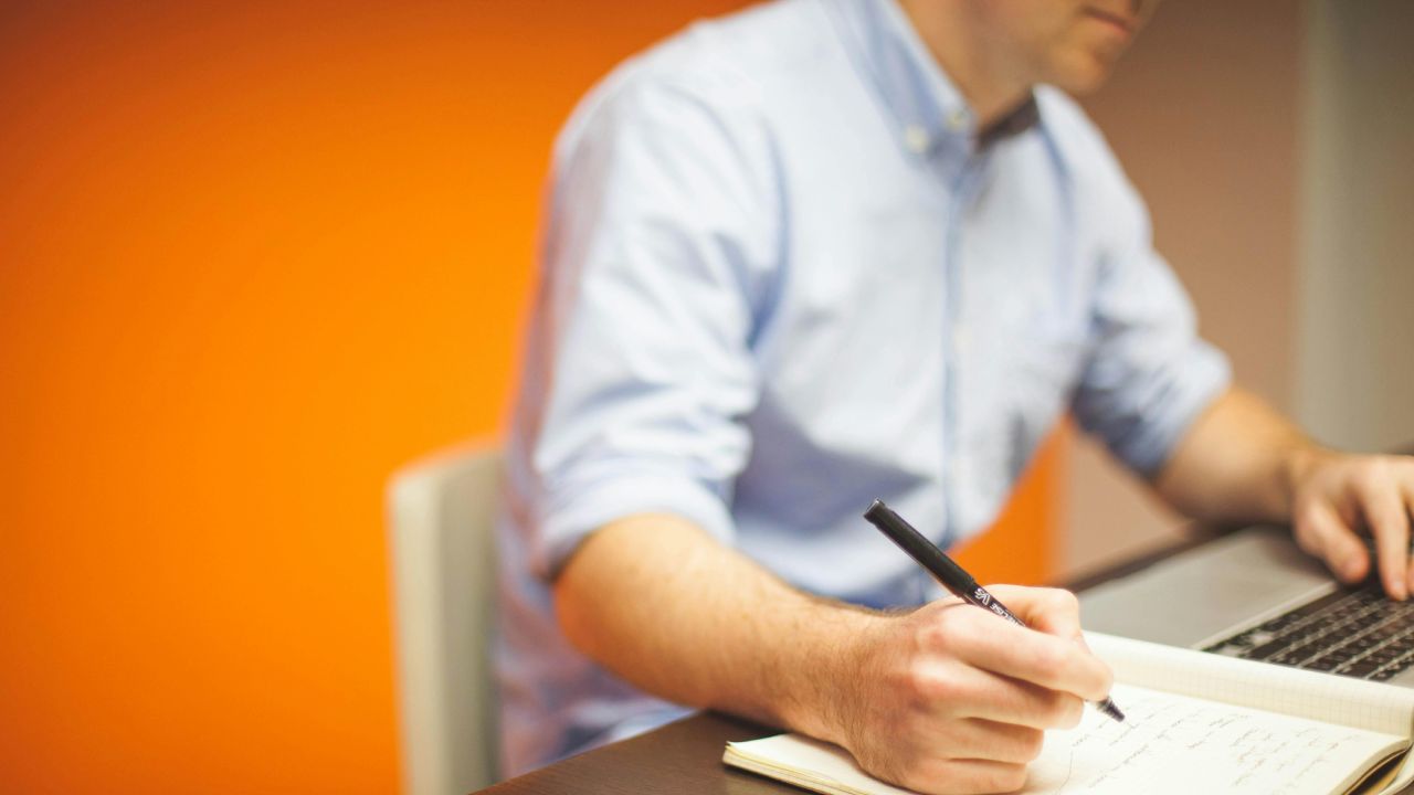 Uomo che scrive mentre lavora al computer